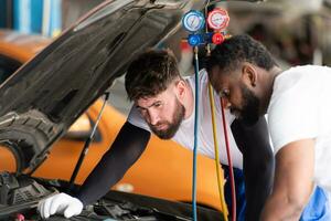 Auto Mechaniker Arbeiten im ein Auto Reparatur Geschäft, inspizieren das Betrieb von das Autos Luft Conditioner und Kältemittel. foto