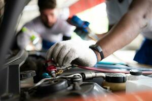 Auto Mechaniker Arbeiten im ein Auto Reparatur Geschäft, inspizieren das Betrieb von das Autos Luft Conditioner und Kältemittel. foto