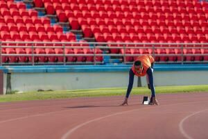 deaktiviert Sportler bereiten im beginnend Position bereit zu Lauf auf Stadion Spur foto