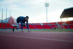 deaktiviert Sportler bereiten im beginnend Position bereit zu Lauf auf Stadion Spur foto