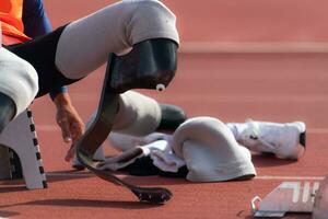 deaktiviert Sportler bereiten im beginnend Position bereit zu Lauf auf Stadion Spur foto