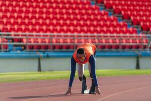 deaktiviert Sportler bereiten im beginnend Position bereit zu Lauf auf Stadion Spur foto