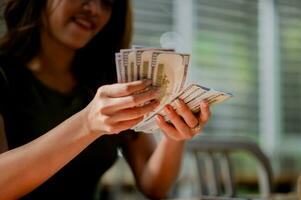 Dollar Währung asiatisch Mädchen Zählen Geld, Gehalt, Einkommen von finanziell Investitionen, Kasse Fluss, Einkaufen und Zahlungen. foto