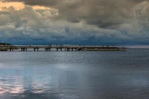 hölzern Seebrücke im das Sonnenuntergang foto