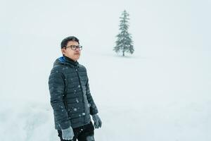 Mann Tourist Besuch im Biei, Reisender im Sweatshirt Besichtigung Weihnachten Baum mit Schnee im Winter Jahreszeit. Wahrzeichen und Beliebt zum Sehenswürdigkeiten im Hokkaido, Japan. Reise und Ferien Konzept foto