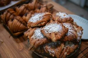 hausgemacht Croissant mit geschnitten Mandel auf Glas und auf Holz Hintergrund beim Cafe. foto