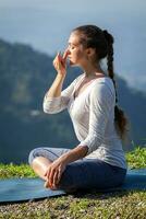 Frau Praktiken Methoden Ausübungen Pranayama im Lotus Pose draußen foto