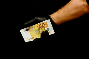 ein Person im ein Grün Handschuh halten oben ein Bank Hinweis foto