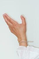 Frau Hand und Handgelenk tragen Zirkon funkeln Armbänder einstellen gegen ein Weiß Hintergrund. foto