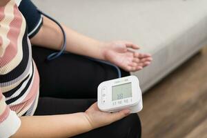 Frau Übergewicht Plus Größe selbst prüft Messung Blut Druck und Herz Bewertung Tonometer selbst Untersuchung beim Zuhause foto