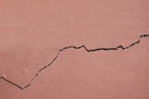 Hintergrund und Textur von horizontal Riss Linie auf Oberfläche von braun Beton Haus Mauer foto