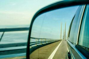 ein Seite Aussicht Spiegel von ein Auto auf ein Brücke foto