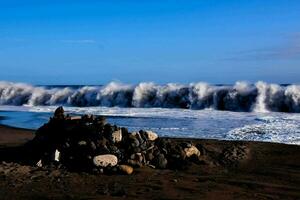 ein groß Welle stürzt ab auf das Strand foto