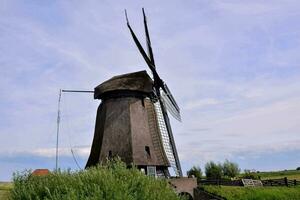 ein Windmühle ist gezeigt im das Mitte von ein Feld foto