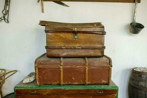 zwei alt Koffer Sitzung auf oben von ein hölzern Truhe foto
