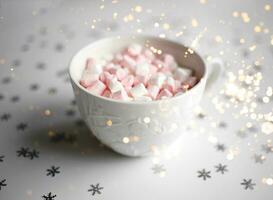 Tasse mit Marshmallows auf ein Weiß Hintergrund mit Silber Schneeflocken foto