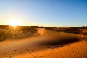 das Sonne steigt an Über das Sahara Wüste foto
