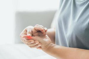 Frau mit Hand- und Fingergelenkschmerzen mit rotem Highlight. rheumatoide Arthritis, Karpaltunnelsyndrom, Gicht. Gesundheitsversorgung und medizinisches Konzept. foto