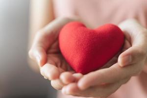 Frau mit rotem Herz, Liebe, Krankenversicherung, Spende, glücklicher Wohltätigkeits-Freiwilliger, Welttag der psychischen Gesundheit, Weltherztag, Valentinstag, foto