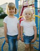 ai generiert süß wenig blond Kinder im ein Weiß T-Shirt und Blau Jeans ist spielen auf das Spielplatz foto
