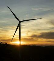 Wind Turbinen auf Sonnenuntergang Hintergrund. natürlich Energie foto