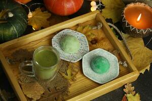 bunt japanisch Süßigkeiten Daifuku oder Mochi geschnitten. Süßigkeiten schließen oben auf das Teller mit Tasse von Matcha Tee foto