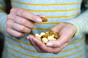 Frau Hände halt ein mischen von Nüsse und Rosine. gesund und lecker Snack. Nahansicht. selektiv Fokus. foto