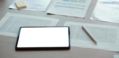 digitales Tablet mit weißem leerem Bildschirm auf dem Tisch. Arbeitsplatz im modernen Bürokonzept. foto
