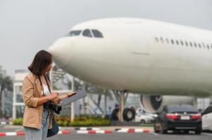 weibliche Reisende finden touristische Informationen auf Tablet, Flugzeughintergrund. foto
