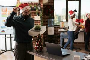 unzufrieden kaukasisch Mann Arbeiter bekommen gefeuert auf Weihnachten, halten Box mit Büro Besitz. Mitarbeiter entlassen von Arbeit Verlassen Arbeitsplatz während Weihnachten Urlaub Feier foto