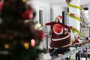 asiatisch Mitarbeiter haben Spaß beim Arbeit mit mitarbeiter, spielen Scharade im festlich dekoriert Büro während Weihnachten Urlaub Jahreszeit. Mitarbeiter Mitglieder Lachen zusammen im Weihnachten aufwendig Arbeitsplatz foto