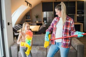 glücklich Mutter und Tochter haben Spaß während Reinigung Haus zusammen foto