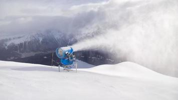 Kanone schießt Schnee im Tourismusgebiet der Schweizer Alpen foto