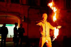 das Kerl auf das Straße führt aus mit Feuer Fackeln foto