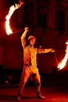 das Kerl auf das Straße führt aus mit Feuer Fackeln foto