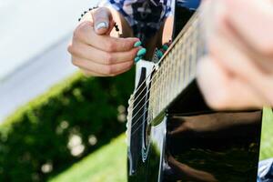 Mädchen auf ein Grün Wiese spielen Gitarre foto