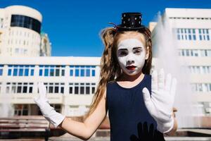 wenig Mime Mädchen zeigt an Pantomime auf das Straße foto