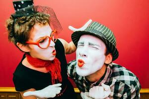 zwei Pantomimen posieren gegen ein rot Mauer Hintergrund foto