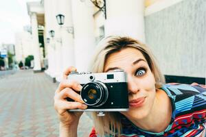 Frau fotografiert retro Kamera im das Stadt foto