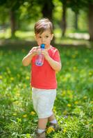 gut aussehend Junge Getränke klar Wasser von ein Flasche auf ein sonnig Tag draußen foto