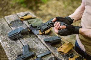 Kerl im das Wald Tests seine Waffen zum Schießen Sport foto