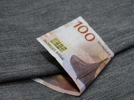 norwegische Banknote von 100 Kronen zwischen blauem Jeansstoff foto