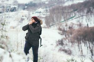 Reisender wärmt seine Hände auf ein Berg foto