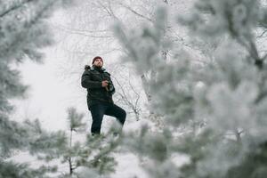 Reisender Fotograf nehmen Bilder im das Winter Wald foto