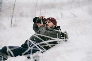 Reisender Fotograf nehmen Bilder im das Winter Wald foto