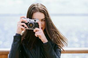 attraktiv Mädchen nimmt Bilder mit ein alt Kamera foto