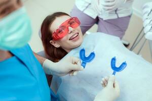 Arzt Kieferorthopäde führt aus ein Verfahren zum Reinigung Zähne foto
