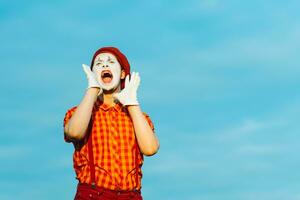 Mime zeigt an Pantomime gegen das Blau Himmel foto