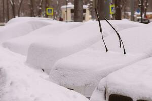 Autos sind geparkt entlang das Straßen bedeckt im Schnee foto