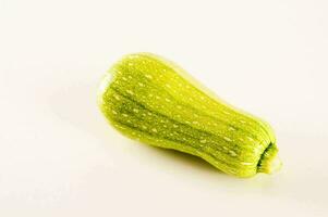 ein Single Zucchini auf ein Weiß Hintergrund foto